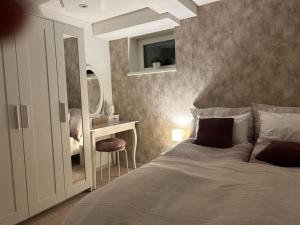 una camera con letto, scrivania e specchio di Wohnung mit Stil im Herzen Tirols a Thaur