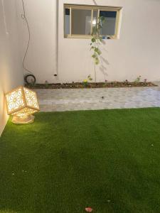 un patio con césped verde y una luz en él en شاليه راقي بمسطحات خضراء وغرفة نوم, en Qufār
