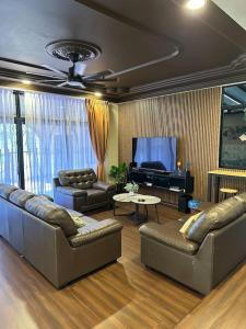 uma sala de estar com dois sofás e um piano em Villa Max Klebang 25 Pax 6R4B em Malaca