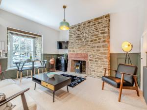 a living room with a stone fireplace and a table at Deacons Apartment 2 - Uk45212 in Chapel en le Frith