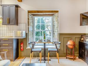 a kitchen with a table and chairs and a window at Deacons Apartment 2 - Uk45212 in Chapel en le Frith