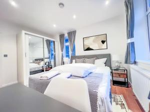 a bedroom with two beds and a mirror at Central London Apartment Camden in London