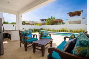 a patio with chairs and a table and a swimming pool at Sosua Ocean Village in Sosúa