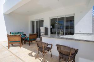 a kitchen and living room with chairs and a counter at Sosua Ocean Village in Sosúa