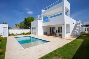 una casa blanca con piscina frente a ella en Sosua Ocean Village, en Sosúa