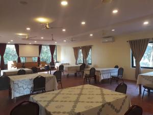 um salão de banquetes com mesas e cadeiras e um ecrã em Lumbini Buddha Garden Resort em Rummindei