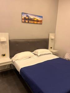 una camera con letto e piumone blu di Oceania Hotels Napoli a Napoli