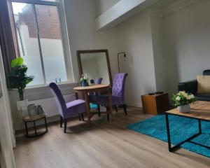 a living room with a table and chairs and a mirror at Stadslogement Goudsteeg 19B in Zwolle