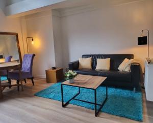 uma sala de estar com um sofá e uma mesa em Stadslogement Goudsteeg 19B em Zwolle