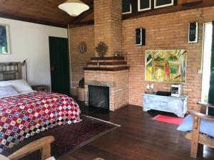 um quarto com uma cama e uma lareira em Quinta da Prata em Bocaina de Minas