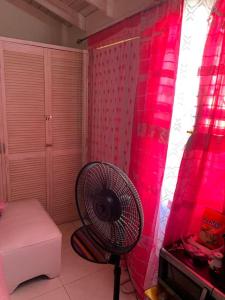 a room with a fan in a room with pink lights at Home In Gated Community 24Hr Security And Wifi in Old Harbour