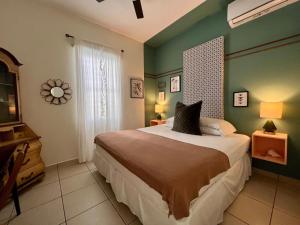 a bedroom with a large bed with green walls at Sonsoleá in Luquillo