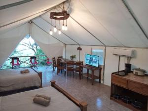 a tent with a dining room and a dining table at Volcano Tenorio Glamping Ranch - 3 Tents in Rio Celeste