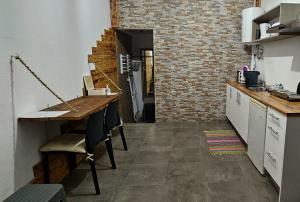 a kitchen with a wooden table and a brick wall at AL - Studio to Travelers in Ponta Delgada