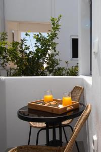 a table with two glasses of orange juice on a balcony at Juliano luxury apartments, port of Naxos in Naxos Chora