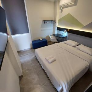 a bedroom with a large white bed and a desk at Rumah Gaharu in Bandung