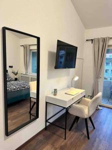 einen Spiegel und einen Schreibtisch in einem Zimmer mit einem Schlafzimmer in der Unterkunft Wohnen im Grünen in Karlsruhe