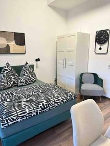 ein Schlafzimmer mit einem Bett und einem Stuhl in der Unterkunft Wohnen im Grünen in Karlsruhe