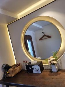 a round mirror on a wall with a table with a mirror at Wonhwaroo in Gyeongju