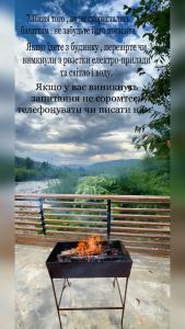 a fire pit in front of a fence with a poem at VIP-Domyk in Rakhiv