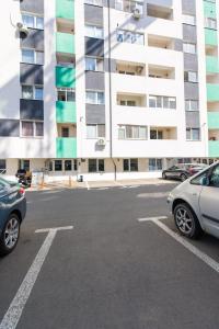 a parking lot with cars parked in front of a building at Suit apartment free parking in Roşu