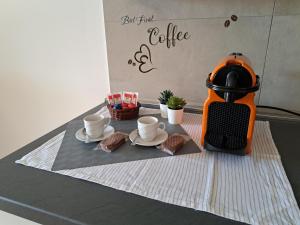 an orange coffee maker sitting on a table with cookies at Angy's house Roma in Rome
