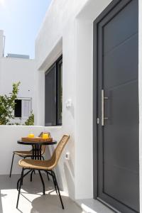 un patio con tavolo e sedie accanto a una porta di Juliano luxury apartments, port of Naxos a Naxos Chora