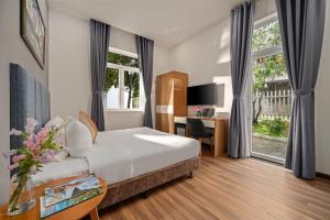 een hotelkamer met een bed en een bureau bij Myrtle Boutique Hotel in Da Lat +34 foto's