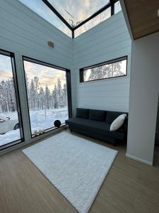 a living room with a blue couch and windows at Levi Aurora Sky in Levi
