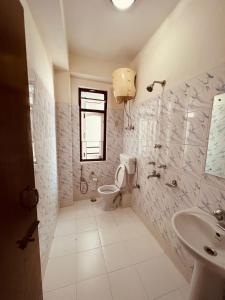 baño con aseo y lavabo y ventana en Mayel-Lyang Residency en Gangtok