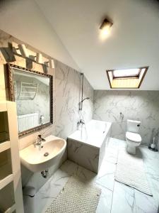 a white bathroom with a sink and a toilet at Stilvolles Studio- Apartment mit einzigartiger Aussicht in Baden