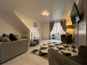 een woonkamer met 2 banken en een tv bij Lingfield House - Spacious 3 Bed Detached Home From Home in Burton upon Trent