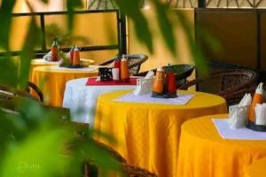 a row of yellow tables with hot dogs on them at Luna hotel in Nakuru