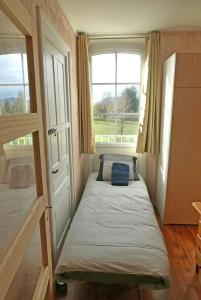 a small bedroom with a bed and two windows at Détente et sport 2 - Chartreuse et Lacs - Chambre chez l'habitant in Saint-Béron