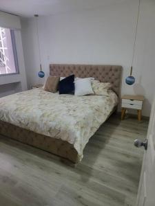 Un dormitorio con una cama grande con almohadas. en departamento en la carolina, en Quito