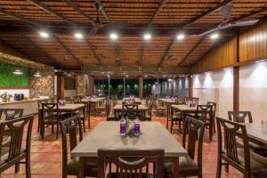 a restaurant with tables and chairs in a room at REVENIIR RESORT Lonavala in Lonavala