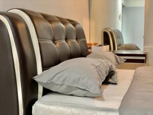 - un lit avec une tête de lit capitonnée brune et un oreiller dans l'établissement Mayura Accomodation, à Kuala Lumpur