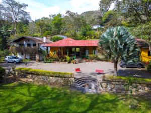una casa con una palmera delante de ella en Finca Alcalá, un paraíso cerca a Bogotá! en Ubaque