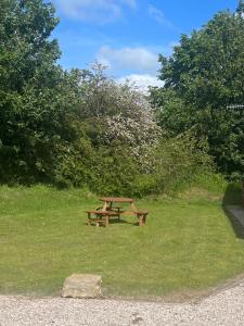 a wooden picnic table in a field of grass at 8 lakeview in Clitheroe