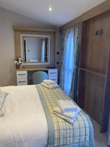 1 dormitorio con cama, escritorio y espejo en 8 lakeview en Clitheroe