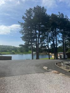 a parking lot next to a lake with trees at 8 lakeview in Clitheroe