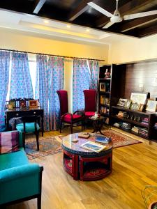 a living room with a table and chairs and a piano at Summer House in Mussoorie