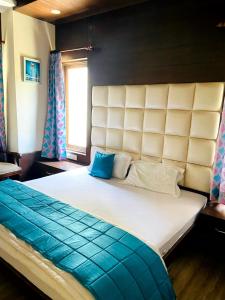 a bedroom with a large bed with a blue pillow at Summer House in Mussoorie