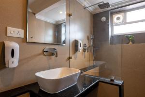 a bathroom with a sink and a shower at La Ben Resort in Colva