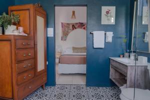 a bathroom with a sink and a toilet and a bedroom at Sonsoleá in Luquillo