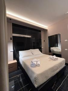 ein Schlafzimmer mit einem großen Bett mit Handtüchern darauf in der Unterkunft Emma Hotel Bologna Fiera in Bologna