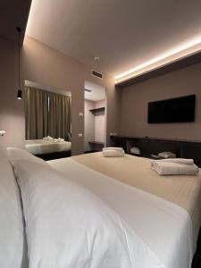 a bedroom with two beds and a flat screen tv at Emma Hotel Bologna Fiera in Bologna