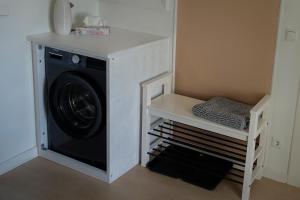 uma lavandaria com uma máquina de lavar roupa e uma prateleira em Wohnen am Bahnhof em Lübeck