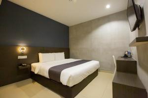 a bedroom with a bed and a television in it at 1 Hotel Signature in Port Dickson