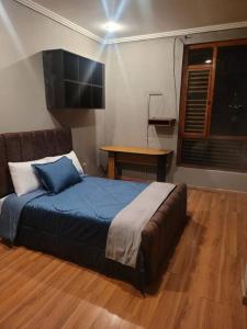 a bedroom with a bed and a table in it at hermosa casa en cuenca in Cuenca